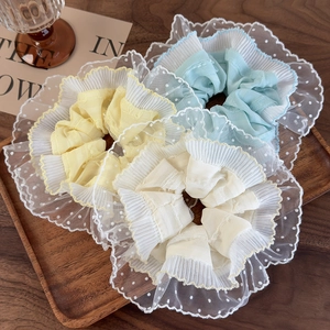 Set of 3 French style lace scrunchies in pastel colors on a wooden tray