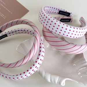 Pink striped and polka dot sponge headbands with handmade label on elegant shell tray