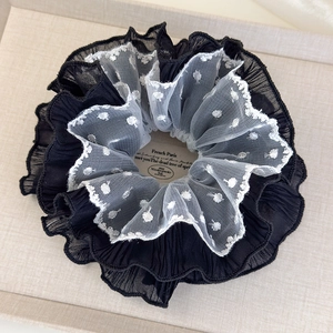 Detailed macro view of layered black chiffon and white polka dot mesh lace hair scrunchie