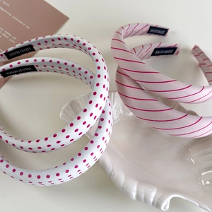 Detail of handmade ballet pink headband with red polka dots and stripes texture