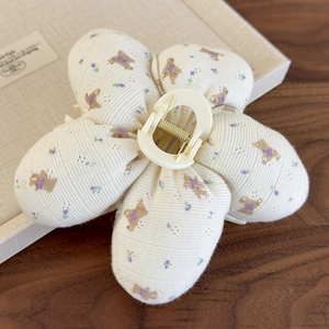 Détail d'une pince à cheveux en peluche avec motifs d'ours et de fleurs violettes au style doux