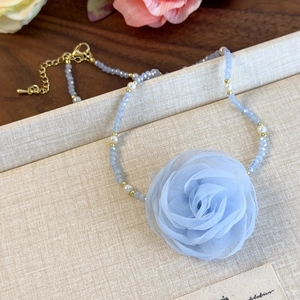 Detail of light blue mesh rose pendant and faceted glass beaded choker necklace