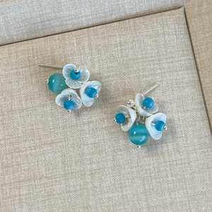 Detail of lily of the valley floral stud earrings with mint beads and shell petals