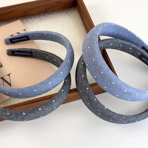 Polka dot denim wide headband for women in light blue and grey tones on a wooden tray
