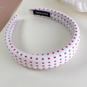 Close-up of pink polka dot wide headband showing the interior handmade fabric label