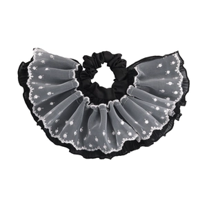 Close-up of vintage lace scrunchie with white polka dots and delicate mesh layers