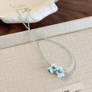 Fresh mint green beaded necklace with white lily flower charms and silver metal clasp