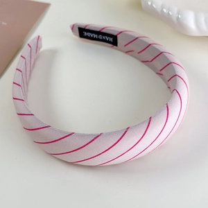 Detailed view of the handmade label and pink red striped fabric texture of the headband