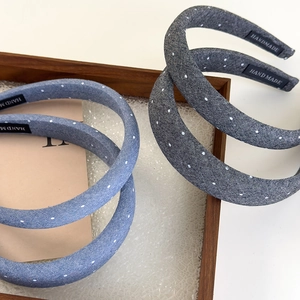 Detailed view of handmade denim headbands with polka dots and handmade labels in a tray