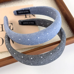 Detail of handmade denim headbands with white polka dots in blue and dark grey tones