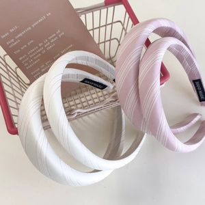 Detail of pink and cream striped fabric headbands with handmade tag and mini cart
