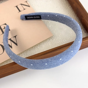 Close-up of blue polka dot denim headband featuring an authentic hand made fabric label