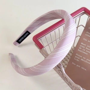 Detail of light pink striped fabric headband with sponge padding and handmade woven label
