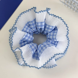 Close-up of blue plaid scrunchie with layered lace pleats and wavy edge details