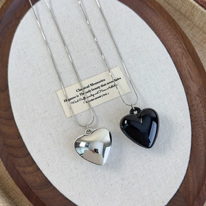 Silver snake chain necklaces featuring polished metal and black enamel 3D heart pendants