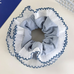 Detail of blue scrunchie with layered lace mesh and navy embroidered scalloped edges
