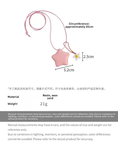 Détail du pendentif étoile rose en résine avec gravure et petite fleur sur cordon ciré