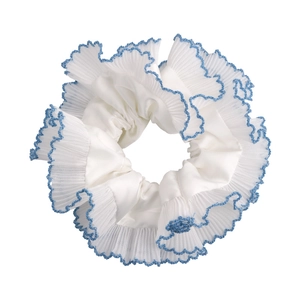 Close-up of the blue wavy lace edge and white sheer pleated fabric of the scrunchie