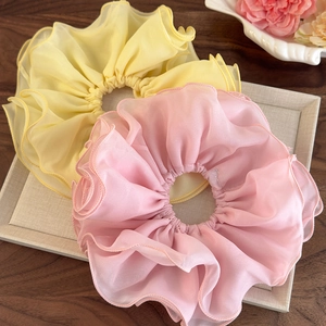 Détail de chouchous surdimensionnés en mousseline double couche en jaune pastel et rose