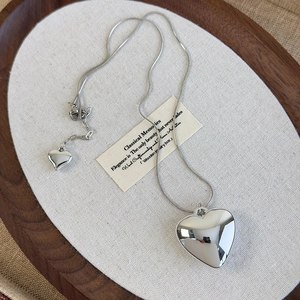 Detailed macro of silver heart pendant with snake bone chain and extension link