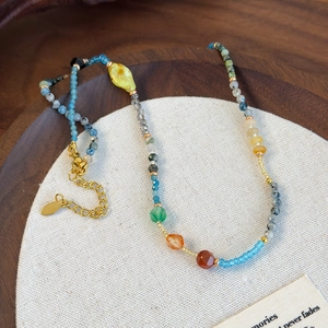 Ethnic style colorful gemstone beaded necklace with adjustable gold lobster clasp on wood