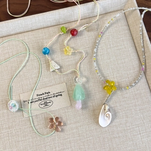 Handmade colorful beaded necklaces set with floral and mushroom charms in soft pastel tones