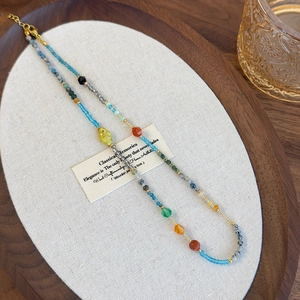 Detailed close-up of colorful glass beads and stones on a bohemian style necklace
