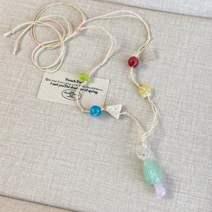Macro detail of handmade colorful beaded necklace with a gradient mushroom glass pendant