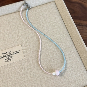 Detailed macro view of beaded mushroom necklace with pink and blue beads in jewelry tray