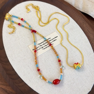 Ethnic style layered beaded necklace with colorful beads and gold snake chain