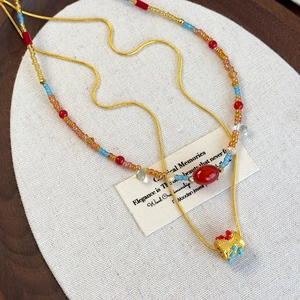 Ethnic style colorful beaded necklace with layered gold snake chain and red gemstone