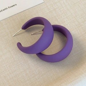 Dettaglio dei orecchini a cerchio a forma di C in resina viola opaca con perni