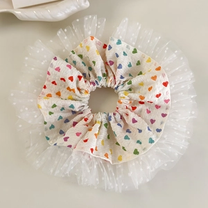Détail de chouchou à imprimé cœurs colorés avec bordure en mesh à pois blancs