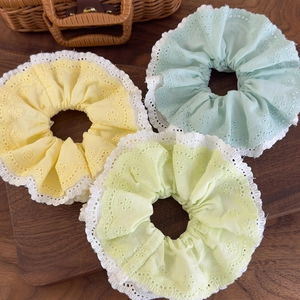 Three-piece set of mint green and pastel floral embroidery lace hair scrunchies on wood