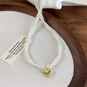 Collier ras du cou à perles doubles couches avec pendentif cœur doré sur plateau