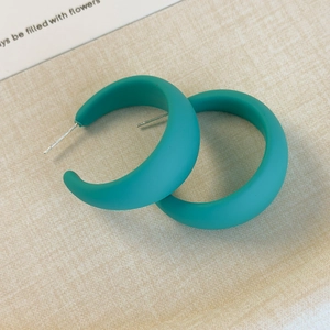 Dettaglio di orecchini a cerchio a C color ottanio opaco con perni in argento su sfondo