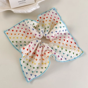 Détail d'un chouchou à motif de cœurs avec bordure ondulée bleue festonnée