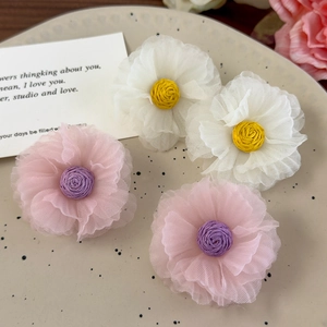 Detailed view of handmade organza floral earrings with woven centers in white and pink