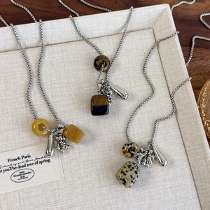 Macro detail of natural stone grape cluster pendants on a silver bead chain