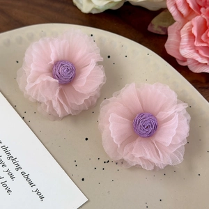 Macro detail of organza flower earrings with pink mesh petals and purple woven center
