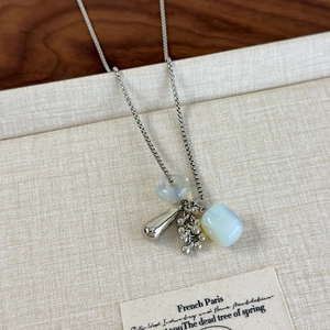 Detail of silver box chain necklace with grape-shaped natural stone and water drop pendants