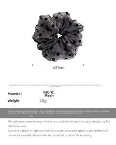 Detail view of a 21cm oversized organza scrunchie with black polka dot patterns