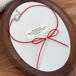 Dettaglio della collana di perline rosse a fiocco con catena di estensione in argento