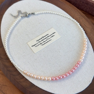 Detail of gradient pink and white pearl necklace with adjustable silver lobster clasp