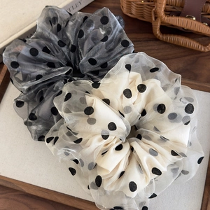 Polka dot organza hair scrunchies set in grey and cream white on a wooden tray