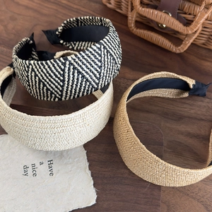 Detailed macro shot of three straw woven headbands in black, beige and brown textures
