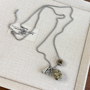 Detailed close-up of marble stone pendants and silver droplet on beaded chain necklace