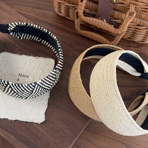 Vintage wide woven straw headbands in khaki, beige, and wave patterns on a wood table