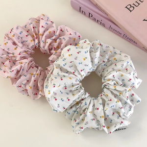 Floral print scrunchies in pink and white fabric for versatile ponytail styling