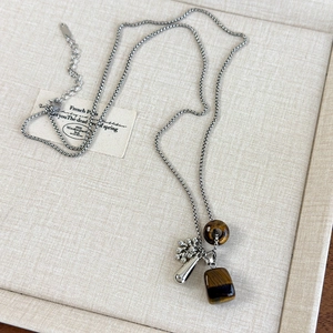 Close-up of bohemian silver box chain necklace with tiger eye stone and drop pendants